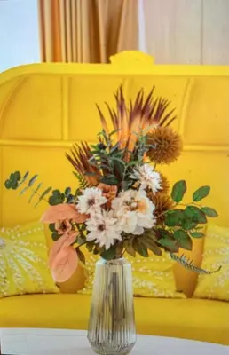 a vase filled with flowers sitting on a table at Reimi Mondo701 in Tokyo
