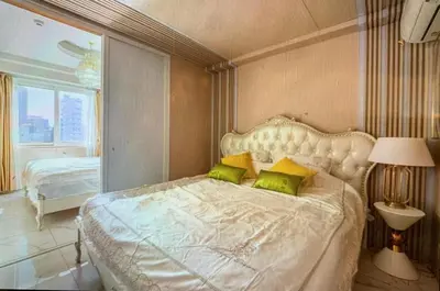 a bedroom with a large white bed with green pillows at Reimi Mondo701 in Tokyo