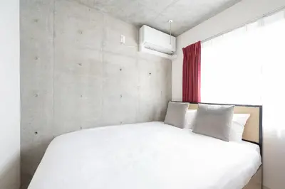 a bedroom with a white bed with a window at Ferio\u84b2\u7530 in Tokyo