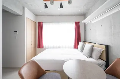 a bedroom with a bed and a table and chairs at Ferio\u84b2\u7530 in Tokyo
