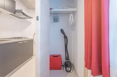 a vacuum in a bathroom with a red shower curtain at Ferio\u84b2\u7530 in Tokyo