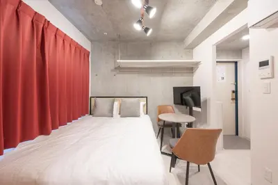 a bedroom with a bed and a red curtain at Ferio\u84b2\u7530 in Tokyo