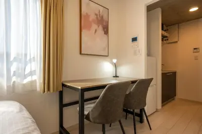 a room with a desk with two chairs and a bed at Ferio\u84b2\u7530 in Tokyo