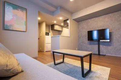 a living room with a table and a flat screen tv at Alterna\u8535\u524d in Tokyo