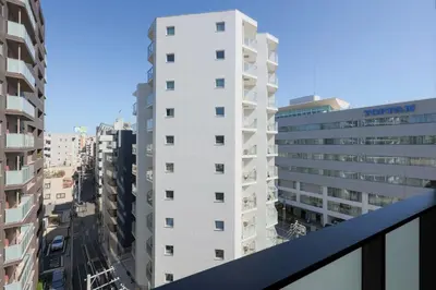 a view of a tall white building from a balcony at Alterna\u8535\u524d in Tokyo