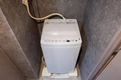 a washing machine in a corner of a room at Alterna\u8535\u524d in Tokyo