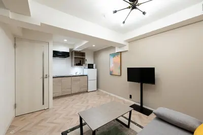 a living room with a couch and a table and a kitchen at belle ville \u795e\u697d\u5742 in Tokyo