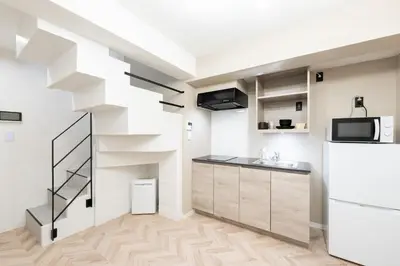 a kitchen with white walls and a spiral staircase at belle ville \u795e\u697d\u5742 in Tokyo