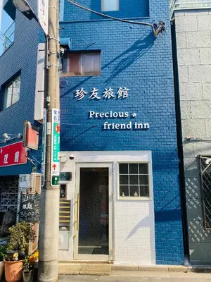 a sign on the side of a blue building at \u99d2\u8fbcJR\u5c71\u624b\u7ebf\u6b65\u884c1min\u5730\u94c1\u76f4\u8fbe\u65b0\u5bbf\u6c60\u888b\u4e0a\u91ce\u4e1c\u4eac\u7ad9\u65e0\u7535\u68af in Tokyo