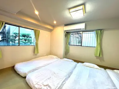 two beds in a room with two windows at \u99d2\u8fbcJR\u5c71\u624b\u7ebf\u6b65\u884c1min\u5730\u94c1\u76f4\u8fbe\u65b0\u5bbf\u6c60\u888b\u4e0a\u91ce\u4e1c\u4eac\u7ad9\u65e0\u7535\u68af in Tokyo