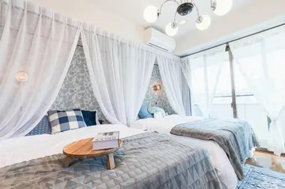 a bedroom with two beds and a table at HARMONIA\u6771\u4eac\u5800\u5207403 in Tokyo