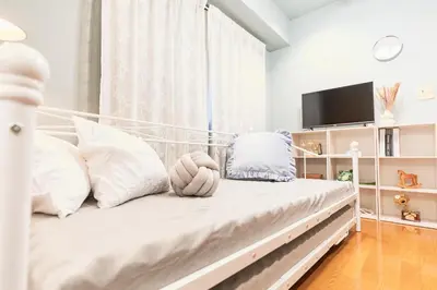 a white bedroom with a bed with white pillows at HARMONIA\u6771\u4eac\u5800\u5207403 in Tokyo