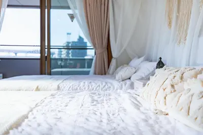 a bedroom with two white beds and a window at HARMONIA\u6771\u4eac\u5800\u5207502 in Tokyo