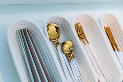 a group of chopsticks and gold spoons and forks at HARMONIA\u6771\u4eac\u5800\u5207502 in Tokyo
