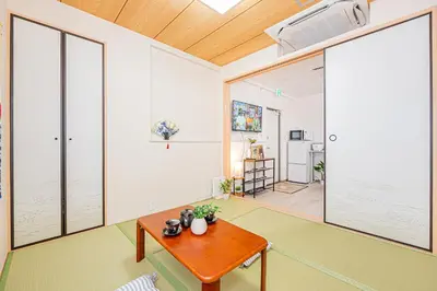 a living room with a table and large windows at Bright Modern Airbnb in Tokyo's Northern District in Tokyo