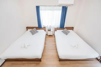 two beds in a small room with blue curtains at Bright Modern Airbnb in Tokyo's Northern District in Tokyo