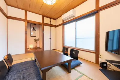 a dining room with a table and a television at GuestHouse　YOU&I平和島 in Tokyo