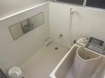 a bathroom with a bath tub and a laptop on a sink at GuestHouse　YOU&I平和島 in Tokyo