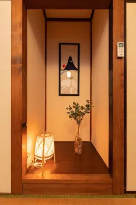 a hallway with a vase on a table with a chair at GuestHouse　YOU&I平和島 in Tokyo