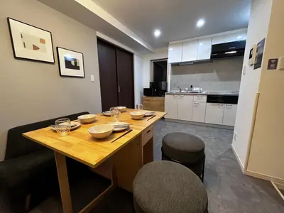 a kitchen with a wooden table with bowls on it at BbyC APARTMENT 浅草花園通 レンタカー&サウナ付ホテル in Tokyo
