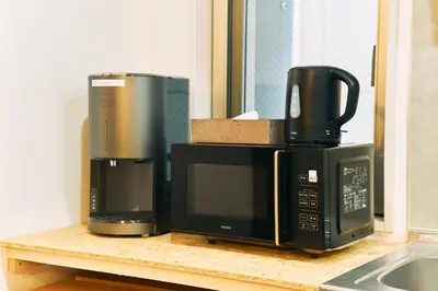two microwaves sitting on top of a counter at BbyC APARTMENT 浅草花園通 レンタカー&サウナ付ホテル in Tokyo