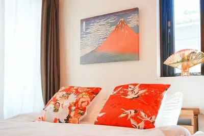 a bedroom with a bed with red pillows and a mountain at The Baron\u897f\u65b0\u5bbf303\u30bb\u30eb\u30d5\u30b3\u30fc\u30d2\u30fc\u4ed8\u304d in Tokyo