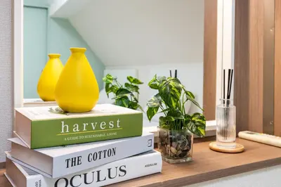 a stack of books on a table with vases and plants at New! Ten people Shin Ookubo 6minPocket WIFI in Tokyo