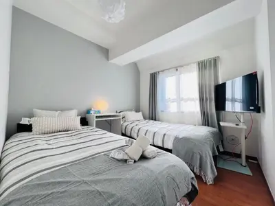 a room with two beds and a tv on a wall at Nishiwaseda-SJ0178 in Tokyo
