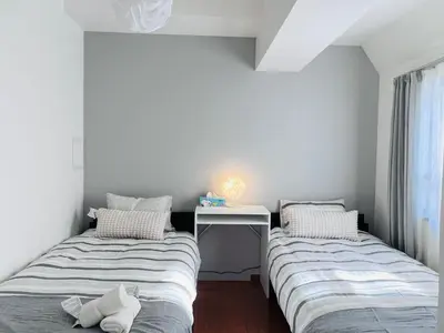 two beds in a room with a table and a desk at Nishiwaseda-SJ0178 in Tokyo