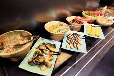 a table with plates of food and bowls of food at Daiwa Roynet Hotel Tokyo Akabane in Tokyo