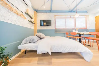 a bedroom with a bed and a dining room at Tokyo Skytree sta 2min walk, 2stop Asakusa sta-Stay SUU & Cafe- in Tokyo
