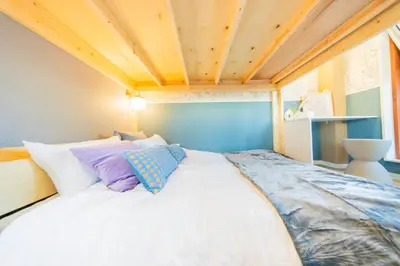 a large bed in a room with a wooden ceiling at Tokyo Skytree sta 2min walk, 2stop Asakusa sta-Stay SUU & Cafe- in Tokyo