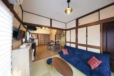 a living room with a blue couch and a table at Est house KAMEARI -Entire Tokyo House with Direct Bus Access to Airport and Disney in a Peaceful Local Neighborhood with 24 Hour Shops and Dining Options- in Tokyo