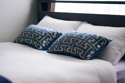 a bed with two pillows on top of it at Est house KAMEARI -Entire Tokyo House with Direct Bus Access to Airport and Disney in a Peaceful Local Neighborhood with 24 Hour Shops and Dining Options- in Tokyo