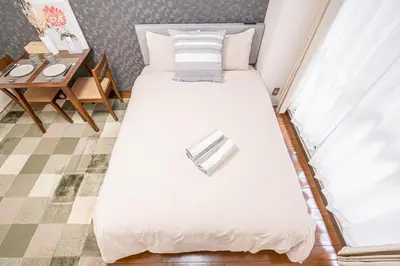 a bedroom with a large white bed and a table at \u65b0\u5bbf\u6b4c\u821e\u4f0e\u753a\u6b65\u884c\u65b0\u5bbf\u5e02\u4e2d\u5fc3\u514d\u8d39Wi-Fi08 in Tokyo