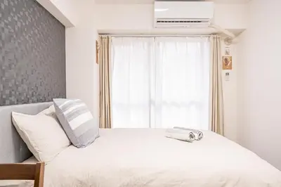 a bedroom with a white bed with a window at \u65b0\u5bbf\u6b4c\u821e\u4f0e\u753a\u6b65\u884c\u65b0\u5bbf\u5e02\u4e2d\u5fc3\u514d\u8d39Wi-Fi08 in Tokyo