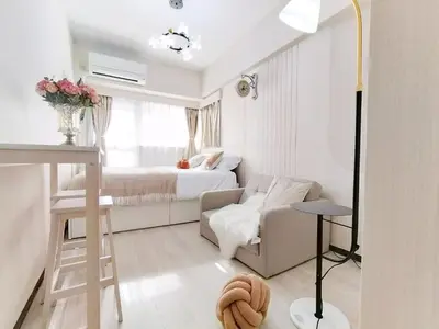 a small white bedroom with a bed and a couch at Z75\u65b0\u5bbf\u6700\u4e2d\u5fc3 \u6771\u65b0\u5bbf\u7ad95\u5206-Shinjuku center 5 mins to Station, Max 3P \u76f4\u8fbe\u65b0\u5bbf \u6d89\u8c37 \u8868\u53c2\u9053 \u6c60\u888b \u4e0a\u91ce \u4ee3\u4ee3\u6728 \u94f6\u5ea7 \u539f\u5bbf in Tokyo
