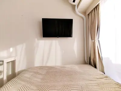 a bedroom with a bed with a television on the wall at Z87\u65b0\u5bbf\u6700\u4e2d\u5fc3 \u6771\u65b0\u5bbf\u7ad95\u5206-Shinjuku center 5 mins to Station, Max 3P \u65b0\u5bbf \u6d89\u8c37 \u8868\u53c2\u9053 \u6c60\u888b \u4e0a\u91ce \u4ee3\u4ee3\u6728 \u94f6\u5ea7 \u539f\u5bbf in Tokyo