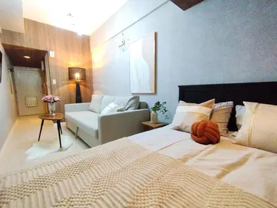 a bedroom with a large bed and a couch at Z22\u65b0\u5bbf\u6700\u4e2d\u5fc3 \u6771\u65b0\u5bbf\u7ad95\u5206-Shinjuku center 5 mins to Station, Max 4 \u76f4\u8fbe\u65b0\u5bbf \u6d89\u8c37 \u8868\u53c2\u9053 \u6c60\u888b \u4e0a\u91ce \u4ee3\u4ee3\u6728 \u94f6\u5ea7 \u539f\u5bbf in Tokyo