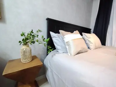 a bed with white pillows and a table with a plant on it at Z22\u65b0\u5bbf\u6700\u4e2d\u5fc3 \u6771\u65b0\u5bbf\u7ad95\u5206-Shinjuku center 5 mins to Station, Max 4 \u76f4\u8fbe\u65b0\u5bbf \u6d89\u8c37 \u8868\u53c2\u9053 \u6c60\u888b \u4e0a\u91ce \u4ee3\u4ee3\u6728 \u94f6\u5ea7 \u539f\u5bbf in Tokyo
