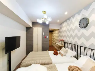 two beds in a bedroom with a tv and a clock at S15\u65b0\u5bbf\u6700\u4e2d\u5fc3 \u6771\u65b0\u5bbf\u7ad95\u5206-Shinjuku center 5 mins to Station, Max 3P \u65b0\u5bbf \u6d89\u8c37 \u8868\u53c2\u9053 \u6c60\u888b \u4e0a\u91ce \u4ee3\u4ee3\u6728 \u94f6\u5ea7 \u539f\u5bbf in Tokyo
