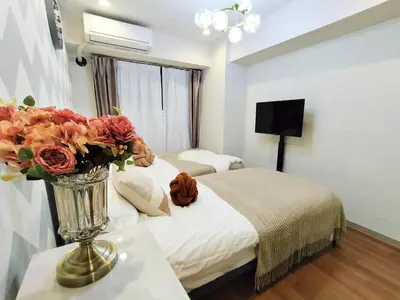 a hotel room with a bed and a vase of flowers at S15\u65b0\u5bbf\u6700\u4e2d\u5fc3 \u6771\u65b0\u5bbf\u7ad95\u5206-Shinjuku center 5 mins to Station, Max 3P \u65b0\u5bbf \u6d89\u8c37 \u8868\u53c2\u9053 \u6c60\u888b \u4e0a\u91ce \u4ee3\u4ee3\u6728 \u94f6\u5ea7 \u539f\u5bbf in Tokyo
