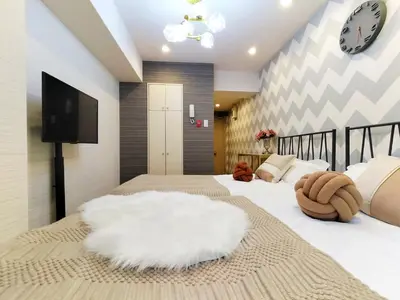 a bedroom with two beds and a tv on the wall at S15\u65b0\u5bbf\u6700\u4e2d\u5fc3 \u6771\u65b0\u5bbf\u7ad95\u5206-Shinjuku center 5 mins to Station, Max 3P \u65b0\u5bbf \u6d89\u8c37 \u8868\u53c2\u9053 \u6c60\u888b \u4e0a\u91ce \u4ee3\u4ee3\u6728 \u94f6\u5ea7 \u539f\u5bbf in Tokyo