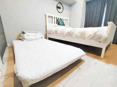 two white beds in a room with a clock on the wall at S22\u65b0\u5bbf\u6700\u4e2d\u5fc3 \u6771\u65b0\u5bbf\u7ad95\u5206-Shinjuku center 5 mins to Station, Max 3P \u76f4\u8fbe\u76f4\u8fbe\u65b0\u5bbf \u6d89\u8c37 \u8868\u53c2\u9053 \u6c60\u888b \u4e0a\u91ce \u4ee3\u4ee3\u6728 \u94f6\u5ea7 \u539f\u5bbf in Tokyo