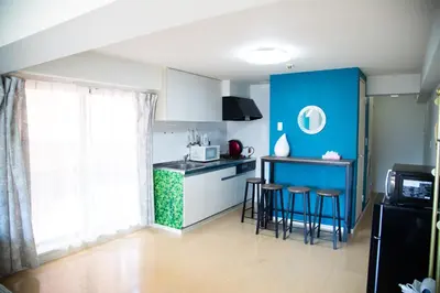 a kitchen with blue walls and stools in a room at S19\u65b0\u5bbf\u6700\u4e2d\u5fc3 \u6771\u65b0\u5bbf\u7ad95\u5206-Shinjuku center 5 mins to Station, Max 6P \u76f4\u8fbe\u65b0\u5bbf \u6d89\u8c37 \u8868\u53c2\u9053 \u6c60\u888b \u4e0a\u91ce \u4ee3\u4ee3\u6728 \u94f6\u5ea7 \u539f\u5bbf in Tokyo