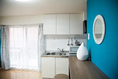 a kitchen with white cabinets and a blue wall at S19\u65b0\u5bbf\u6700\u4e2d\u5fc3 \u6771\u65b0\u5bbf\u7ad95\u5206-Shinjuku center 5 mins to Station, Max 6P \u76f4\u8fbe\u65b0\u5bbf \u6d89\u8c37 \u8868\u53c2\u9053 \u6c60\u888b \u4e0a\u91ce \u4ee3\u4ee3\u6728 \u94f6\u5ea7 \u539f\u5bbf in Tokyo
