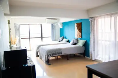 a bedroom with two beds and a blue wall at S19\u65b0\u5bbf\u6700\u4e2d\u5fc3 \u6771\u65b0\u5bbf\u7ad95\u5206-Shinjuku center 5 mins to Station, Max 6P \u76f4\u8fbe\u65b0\u5bbf \u6d89\u8c37 \u8868\u53c2\u9053 \u6c60\u888b \u4e0a\u91ce \u4ee3\u4ee3\u6728 \u94f6\u5ea7 \u539f\u5bbf in Tokyo