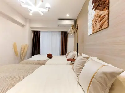 a hotel room with two beds and a chandelier at G53\u65b0\u5bbf\u6700\u4e2d\u5fc3 \u6771\u65b0\u5bbf\u7ad95\u5206-Shinjuku center 5 mins to Station, Max 4P \u76f4\u8fbe\u65b0\u5bbf \u6d89\u8c37 \u8868\u53c2\u9053 \u6c60\u888b \u4e0a\u91ce \u4ee3\u4ee3\u6728 \u94f6\u5ea7 \u539f\u5bbf in Tokyo