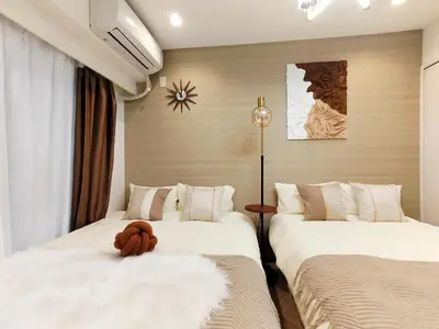two beds in a hotel room with a stuffed animal on them at G53\u65b0\u5bbf\u6700\u4e2d\u5fc3 \u6771\u65b0\u5bbf\u7ad95\u5206-Shinjuku center 5 mins to Station, Max 4P \u76f4\u8fbe\u65b0\u5bbf \u6d89\u8c37 \u8868\u53c2\u9053 \u6c60\u888b \u4e0a\u91ce \u4ee3\u4ee3\u6728 \u94f6\u5ea7 \u539f\u5bbf in Tokyo