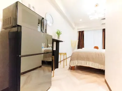 a kitchen with a refrigerator in a room with a bed at G53\u65b0\u5bbf\u6700\u4e2d\u5fc3 \u6771\u65b0\u5bbf\u7ad95\u5206-Shinjuku center 5 mins to Station, Max 4P \u76f4\u8fbe\u65b0\u5bbf \u6d89\u8c37 \u8868\u53c2\u9053 \u6c60\u888b \u4e0a\u91ce \u4ee3\u4ee3\u6728 \u94f6\u5ea7 \u539f\u5bbf in Tokyo